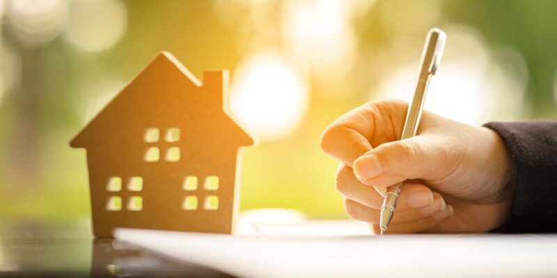 Toy house and mortgage signing